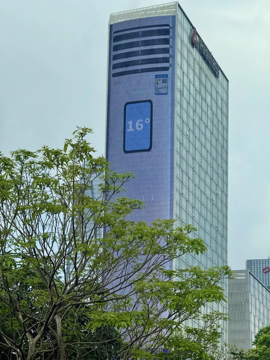 A skyscraper in Shenzhen with a temperature display showing 16 degrees Celsius