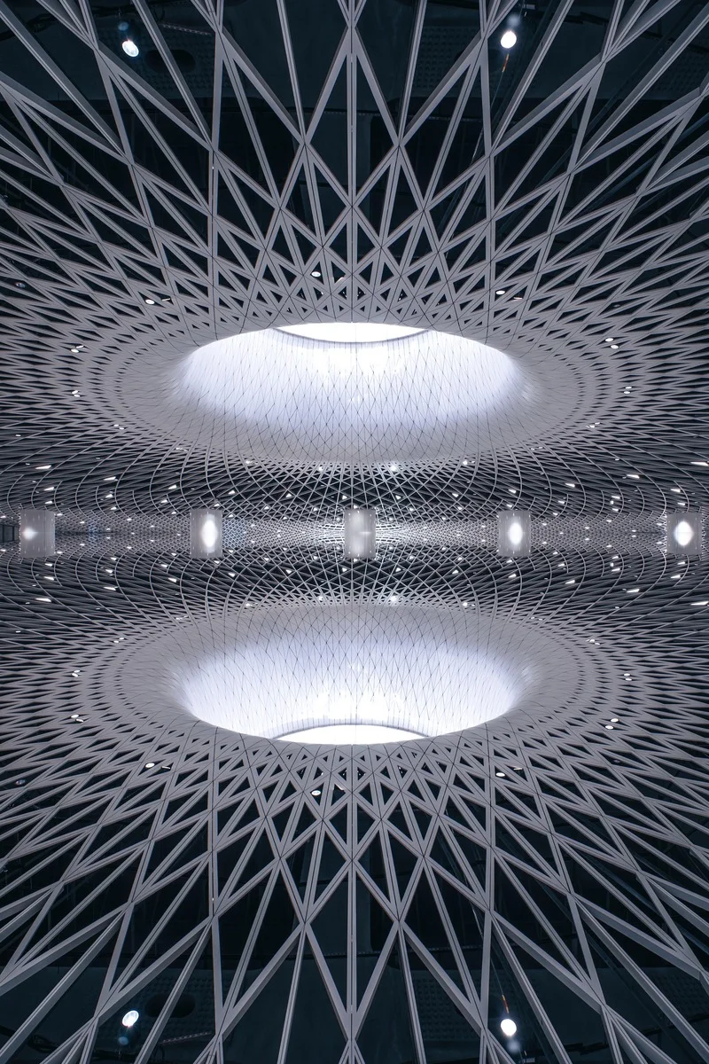 Close-up of the futuristic, geometric ceiling at Gangxia North Metro Station in Shenzhen, featuring concentric light wells an