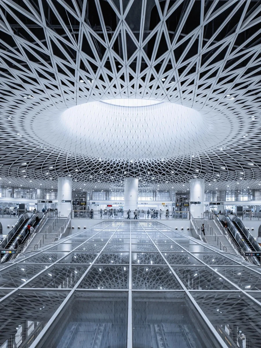 Modern interior of Gangxia Bei Metro Station in Shenzhen, featuring a stunning geometric ceiling and central skylight with gl